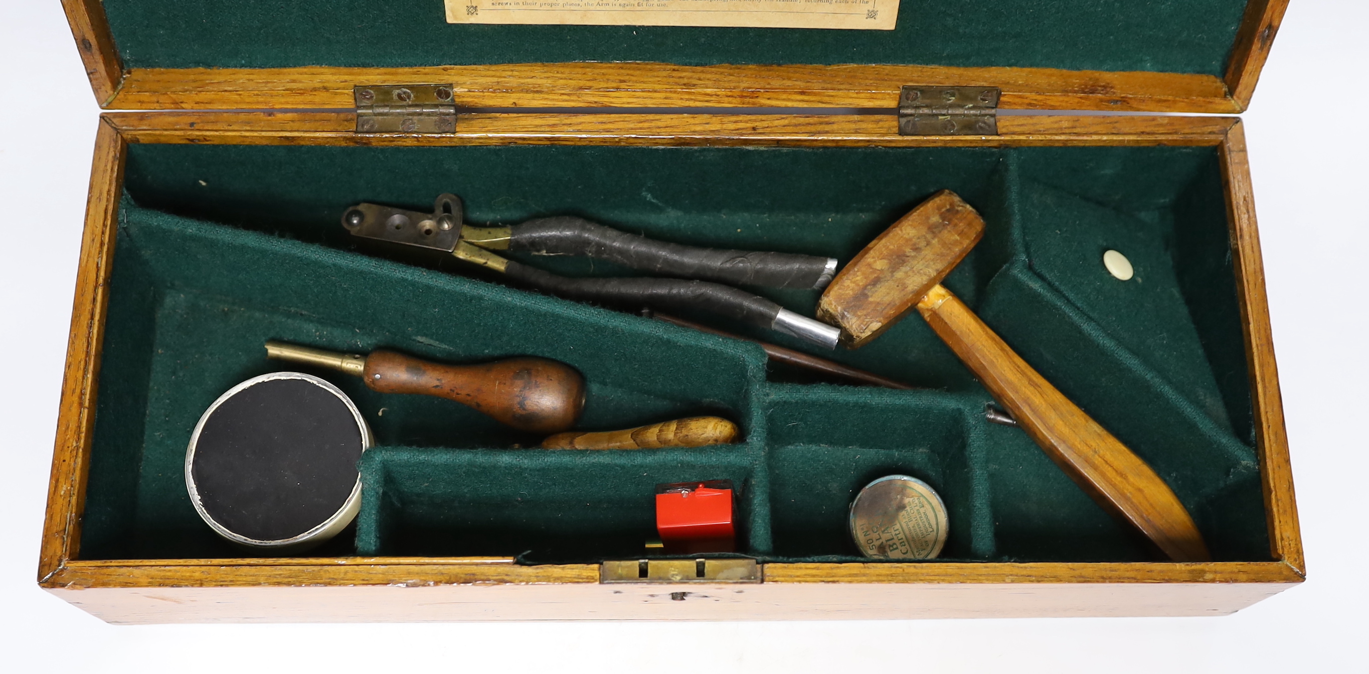 An oak Colt pistol box, felt lined compartments containing a few tools including a bullet mould, label for directions to the inside of the lid, dimensions 45.5 x 18 x 11.5cm